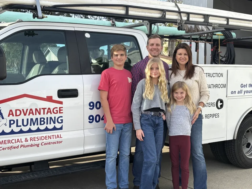 Advantage Plumbing family beside their branded service truck