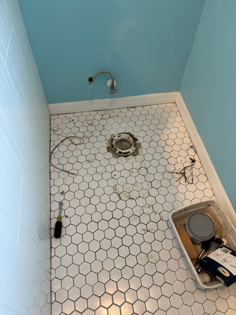 Bathroom floor and flange exposed after the old toilet was removed