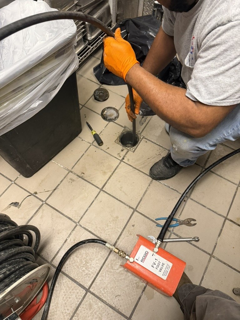 Advantage Plumbing technician hydro jetting a floor drain on a service call