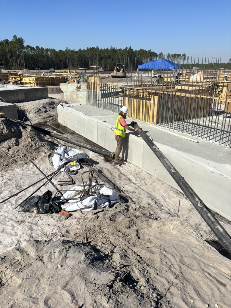 Advantage Plumbing crew member handling wellpoint piping beside the Nocatee foundation