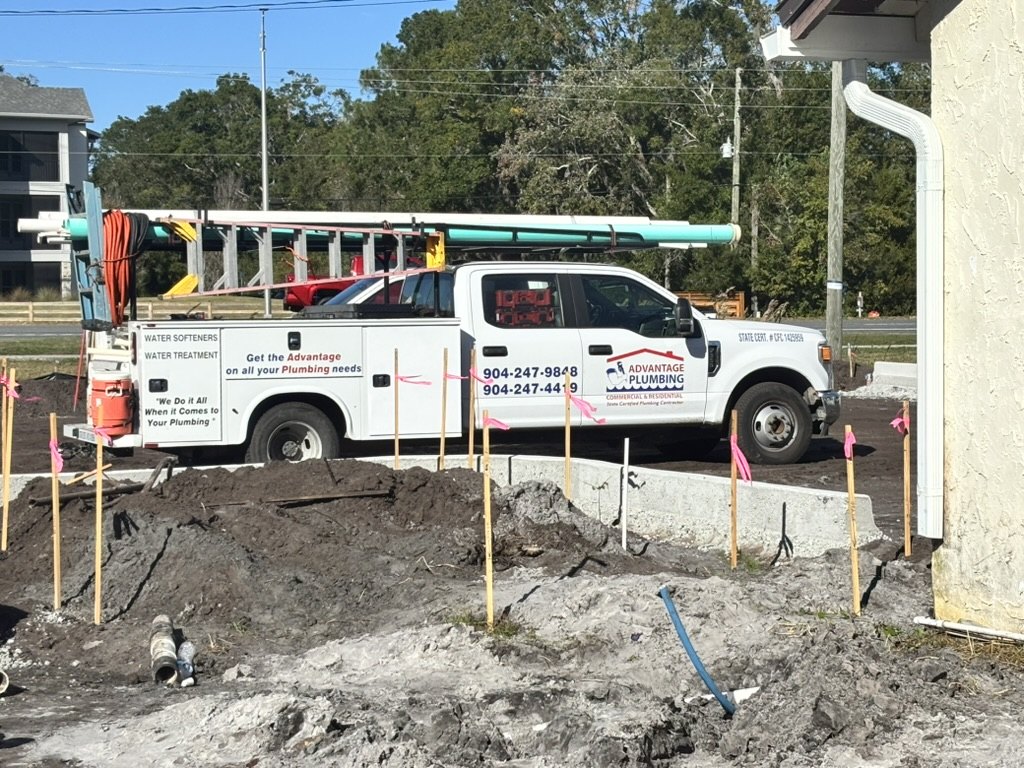 Advantage Plumbing service truck beside exposed piping and an excavated work area