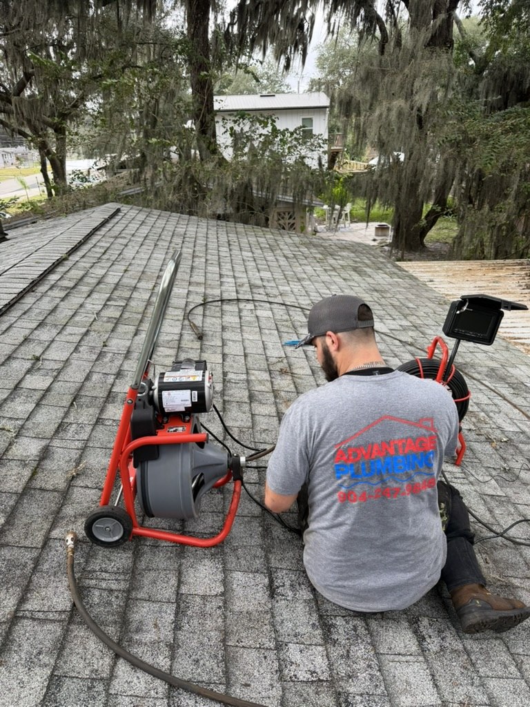 Advantage Plumbing technician working with drain service and camera equipment on the roof