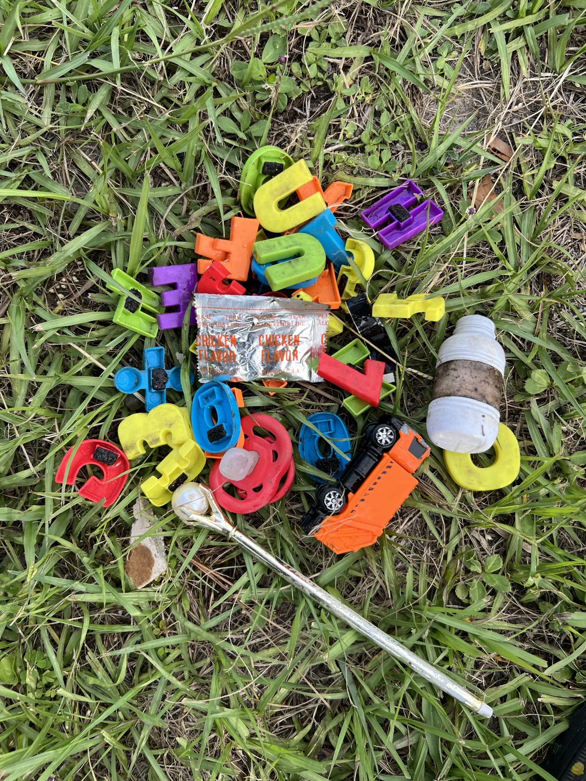 Colorful alphabet letters, toy vehicles and other objects removed from a laundry P-trap