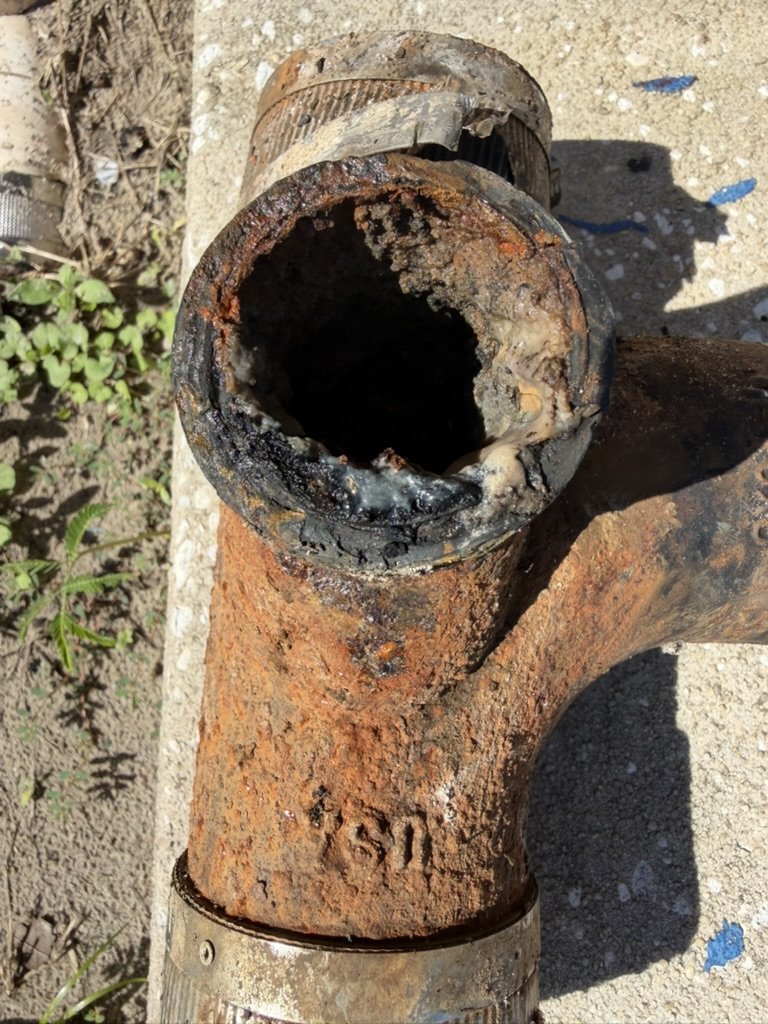 Corroded cast-iron fitting removed from the stack and placed outdoors