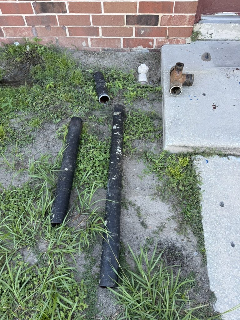 Removed cast-iron pipe sections and fittings beside the building