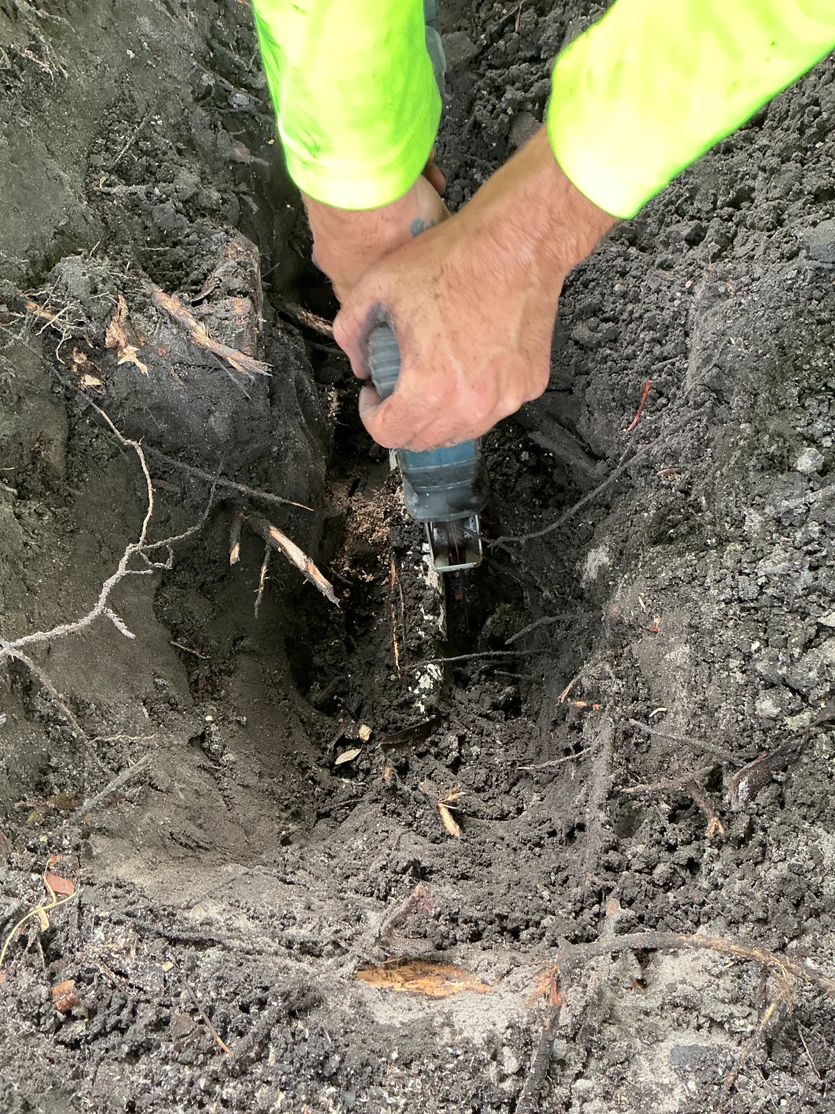 Plumber working around exposed roots in the excavation for the Pablo Bay water-line repair