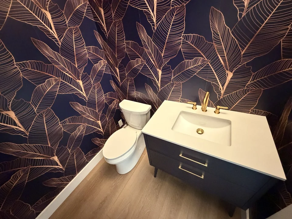 Gold bathroom faucet, vanity sink, and toilet installed by Advantage Plumbing