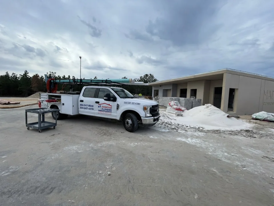 Advantage Plumbing service truck at a commercial building construction site