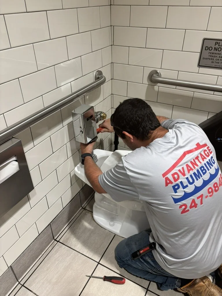 Advantage Plumbing plumber repairing a commercial toilet flush valve
