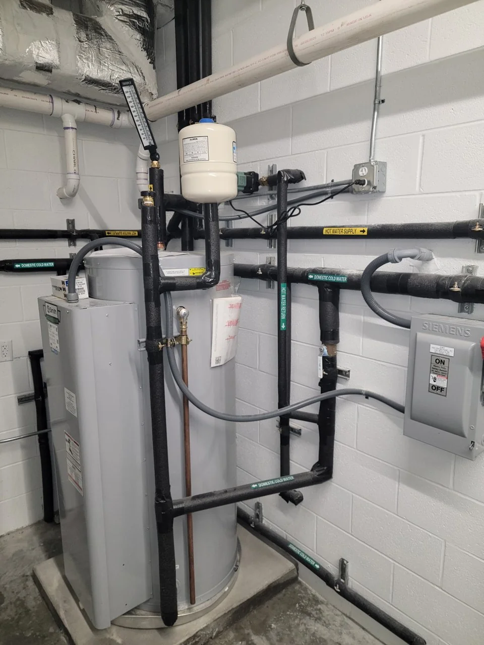 Commercial water heater with expansion tank and insulated water piping at a recent project