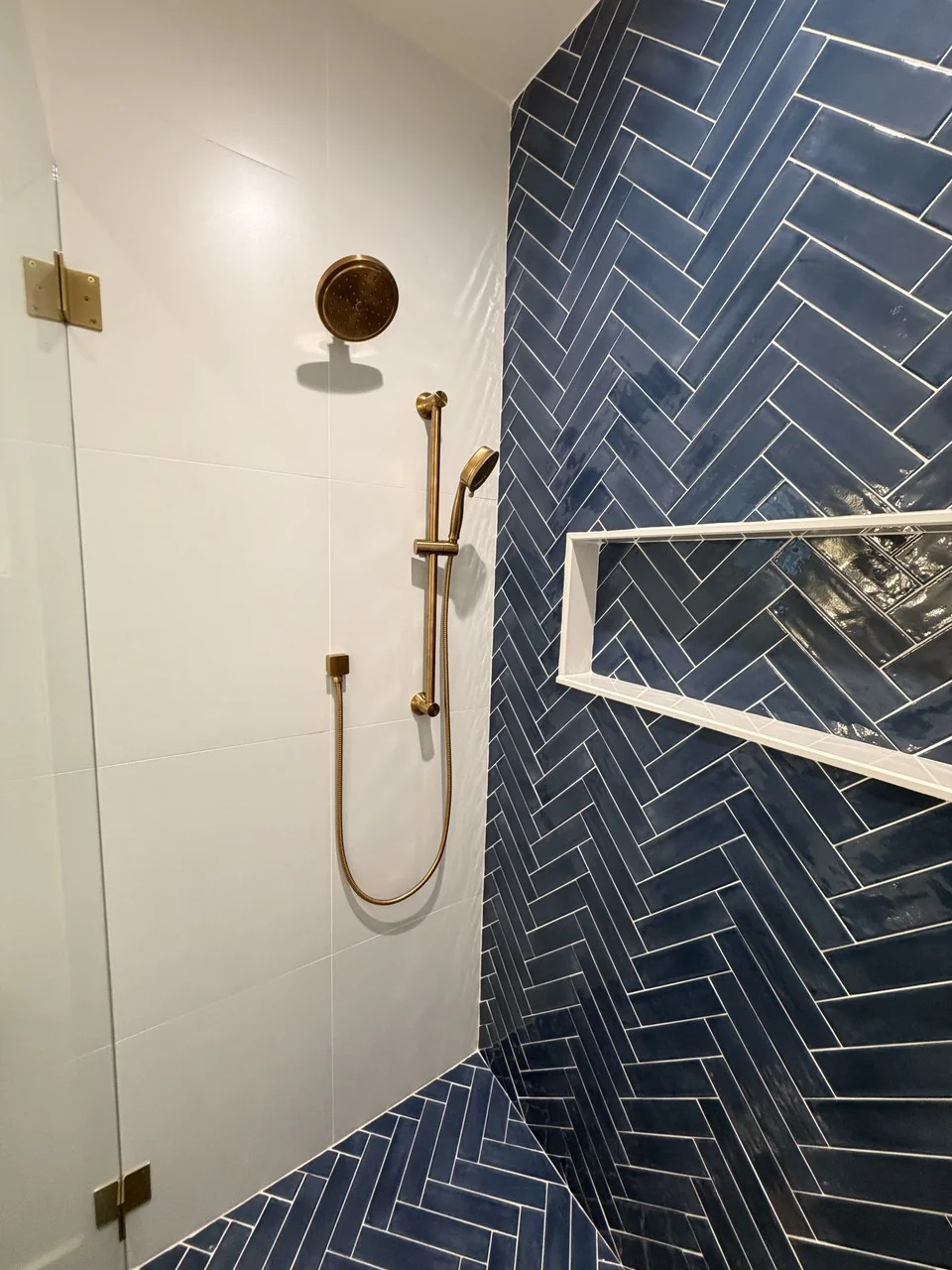 Shower head and handheld shower installed by Advantage Plumbing in a tiled shower