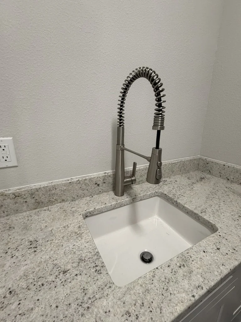 Replacement laundry-room faucet and sink after a broken faucet was replaced by Advantage Plumbing